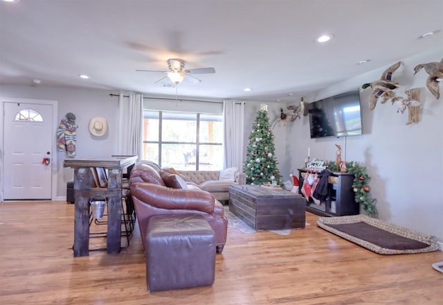 living room featuring wood-type flooring and ceiling fan