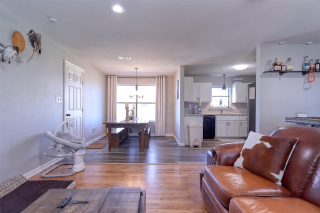 living room featuring hardwood / wood-style floors, a notable chandelier, and a healthy amount of sunlight