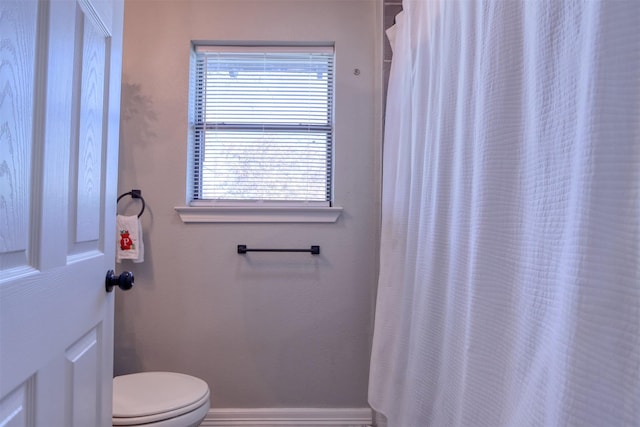 bathroom with curtained shower and toilet