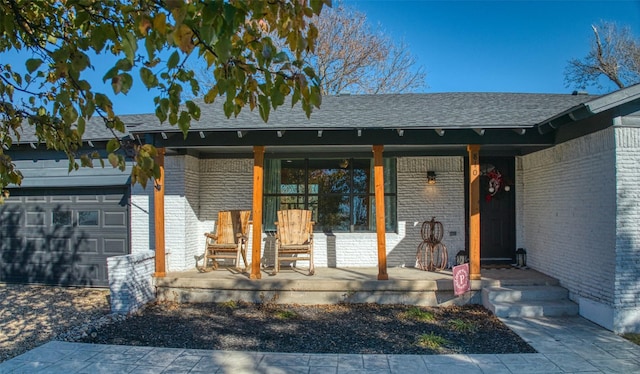 view of exterior entry featuring a porch and a garage