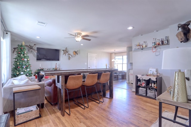 living room with ceiling fan and light hardwood / wood-style floors