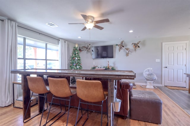 bar with hardwood / wood-style flooring and ceiling fan