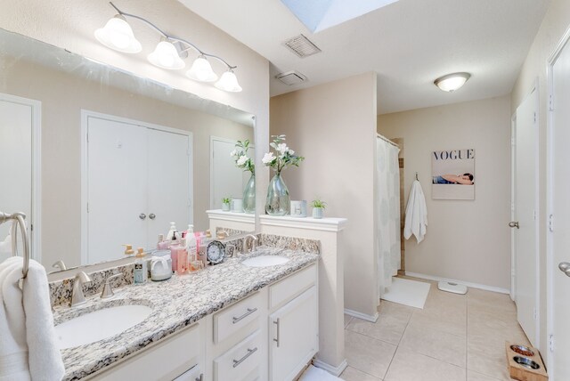 kitchen featuring backsplash, sink, light tile patterned floors, appliances with stainless steel finishes, and white cabinetry