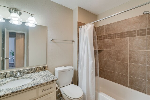 full bathroom with vanity, toilet, and shower / tub combo with curtain