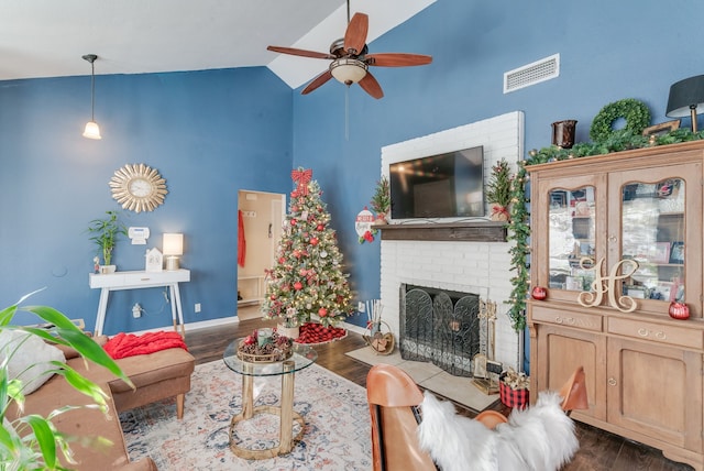 living room with ceiling fan, dark wood-type flooring, high vaulted ceiling, and a brick fireplace