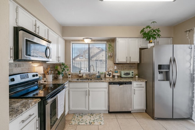 kitchen featuring sink, decorative backsplash, stainless steel appliances, and white cabinets