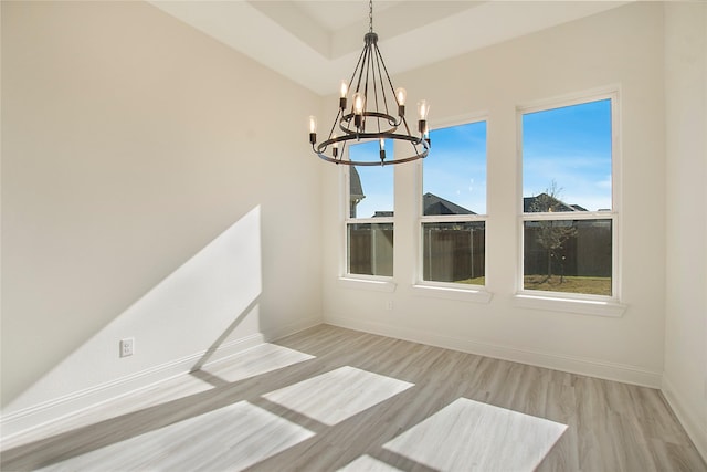 unfurnished dining area with light hardwood / wood-style flooring and a notable chandelier