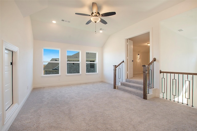 interior space with ceiling fan, light colored carpet, and vaulted ceiling