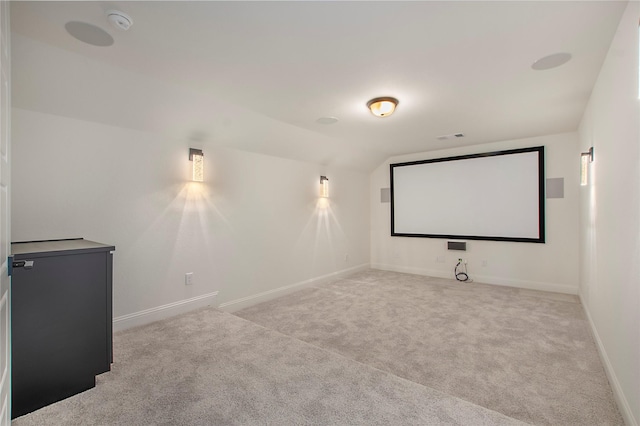 home theater with vaulted ceiling and light colored carpet