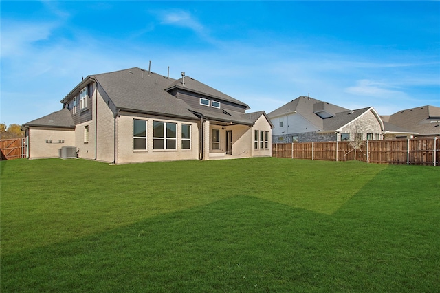 back of property with cooling unit and a lawn