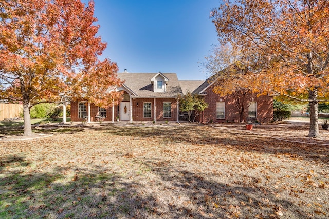 new england style home featuring a front yard