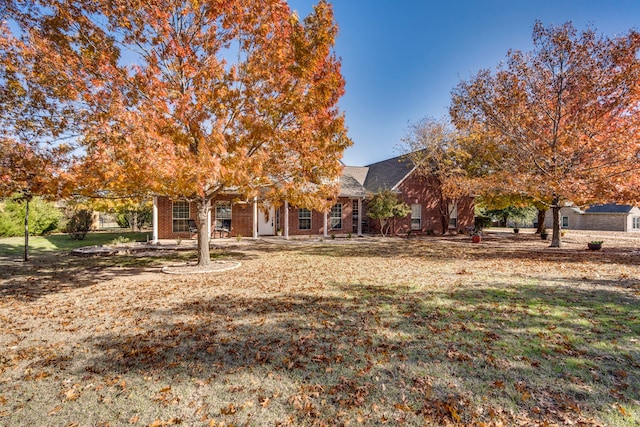 view of property hidden behind natural elements featuring a front yard