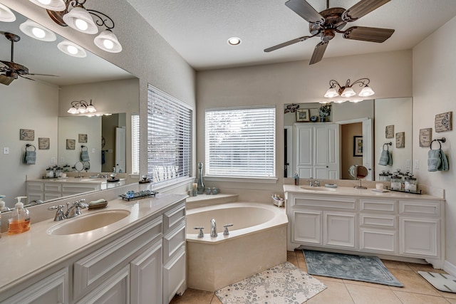 bathroom featuring a bathtub, vanity, tile patterned floors, ceiling fan, and a textured ceiling