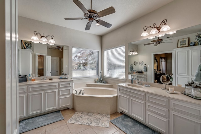 bathroom with tile patterned flooring, vanity, a textured ceiling, and a tub