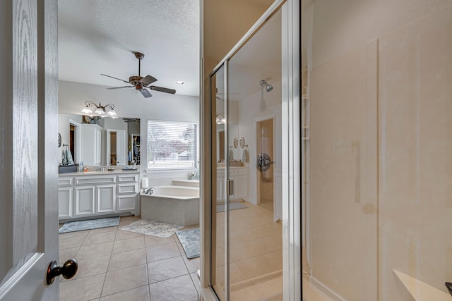 bathroom featuring vanity, tile patterned floors, ceiling fan, separate shower and tub, and a textured ceiling