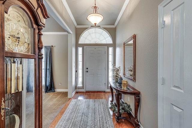 foyer with plenty of natural light, light wood-type flooring, and ornamental molding