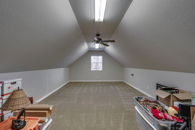 additional living space featuring carpet flooring, a textured ceiling, vaulted ceiling, and ceiling fan