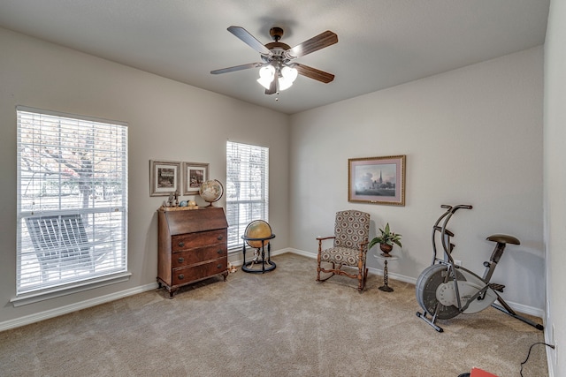 living area with ceiling fan, light colored carpet, and a wealth of natural light