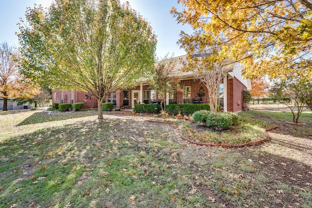 view of property hidden behind natural elements with a front yard