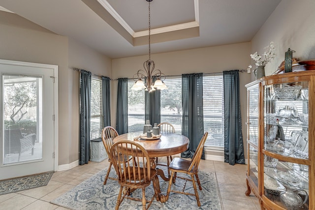 tiled dining space featuring a raised ceiling, crown molding, and a notable chandelier