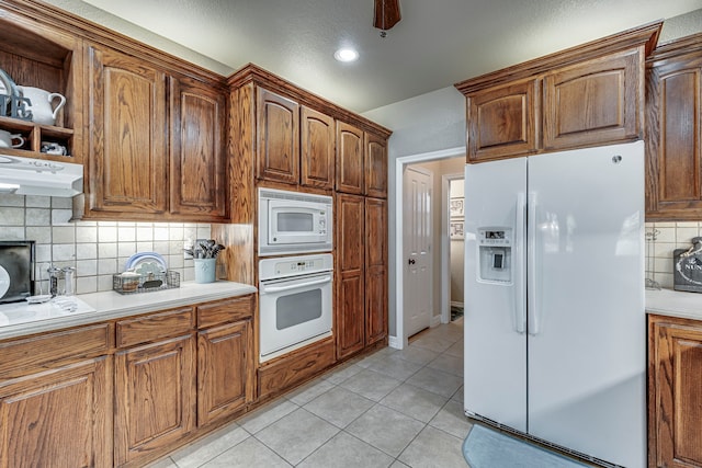 kitchen with backsplash, ceiling fan, light tile patterned flooring, and white appliances