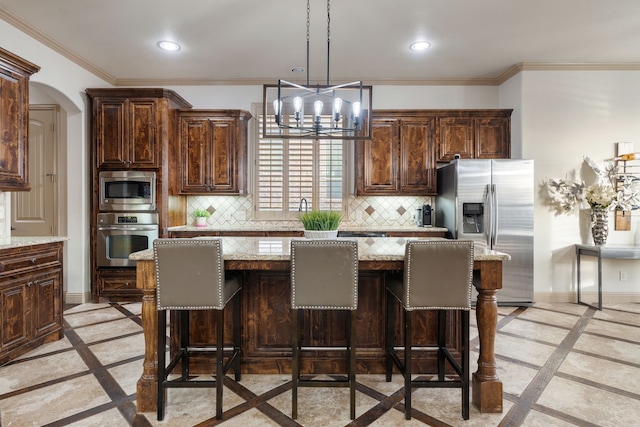 kitchen with a center island, light stone counters, and stainless steel appliances