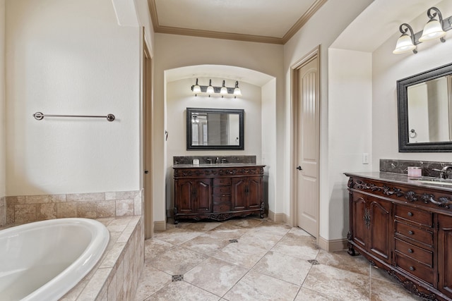 bathroom featuring tiled bath, crown molding, and vanity