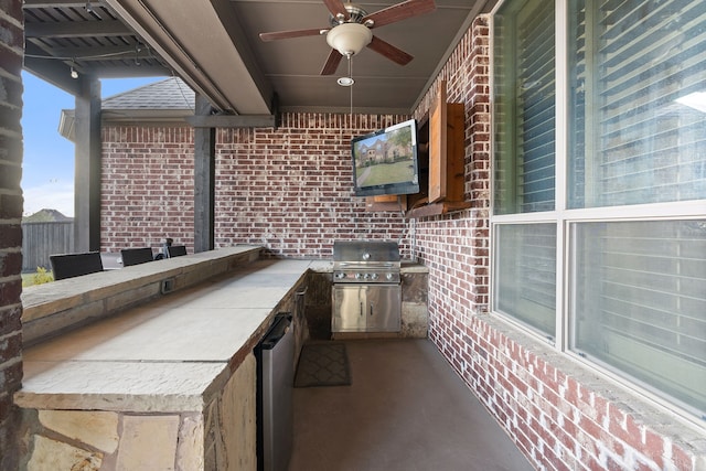 view of patio / terrace featuring grilling area, ceiling fan, an outdoor bar, and an outdoor kitchen