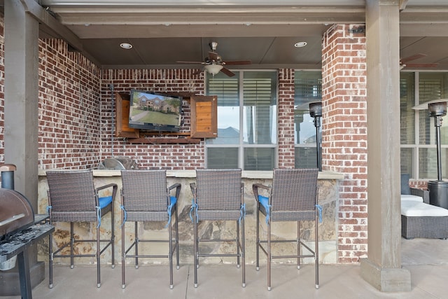 view of patio with exterior bar and ceiling fan