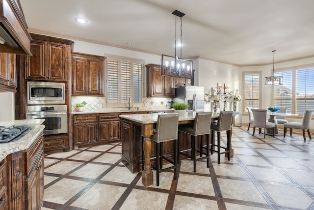 kitchen with tasteful backsplash, a center island, an inviting chandelier, and appliances with stainless steel finishes