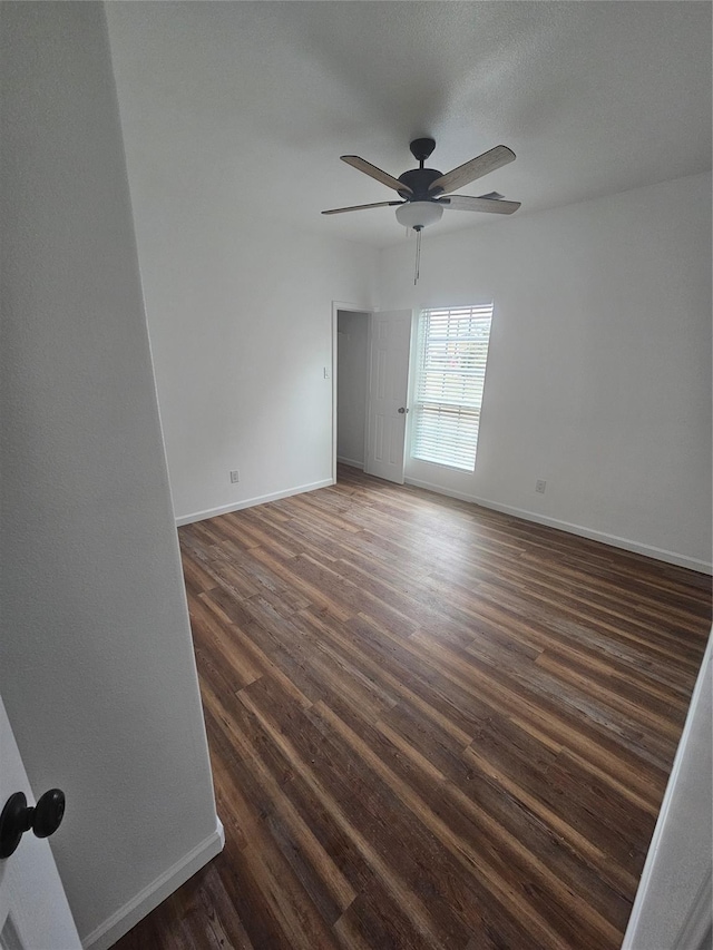 unfurnished room with ceiling fan and dark wood-type flooring