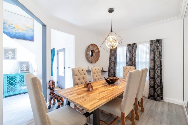 dining space with ornamental molding, a healthy amount of sunlight, and light wood-type flooring