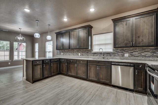 kitchen with hanging light fixtures, light wood-type flooring, sink, and appliances with stainless steel finishes