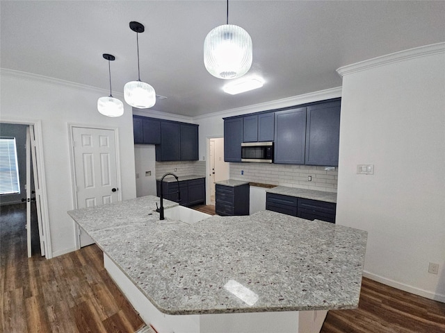 kitchen with backsplash, a sink, stainless steel microwave, and dark wood-style flooring