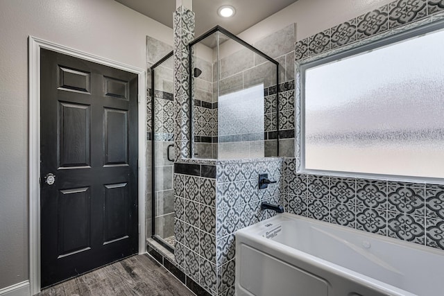 bathroom with shower with separate bathtub and hardwood / wood-style flooring