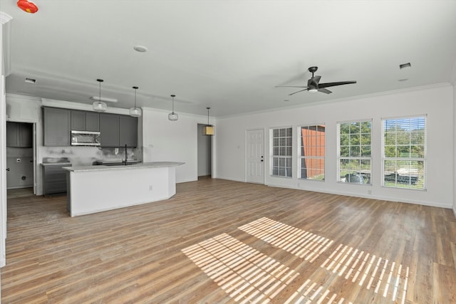 unfurnished living room with light hardwood / wood-style floors, ceiling fan, and ornamental molding