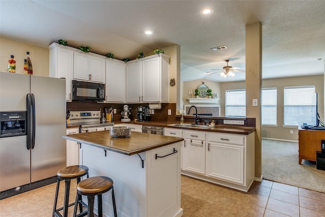 kitchen with ceiling fan, sink, white cabinets, and stainless steel appliances