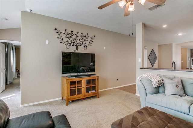 carpeted living room with sink and ceiling fan