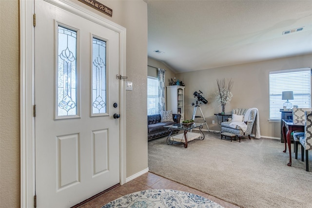 entryway featuring a textured ceiling, light carpet, and vaulted ceiling