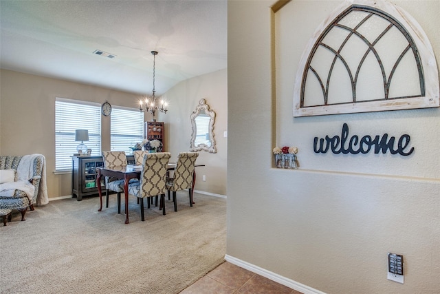 carpeted dining area with an inviting chandelier