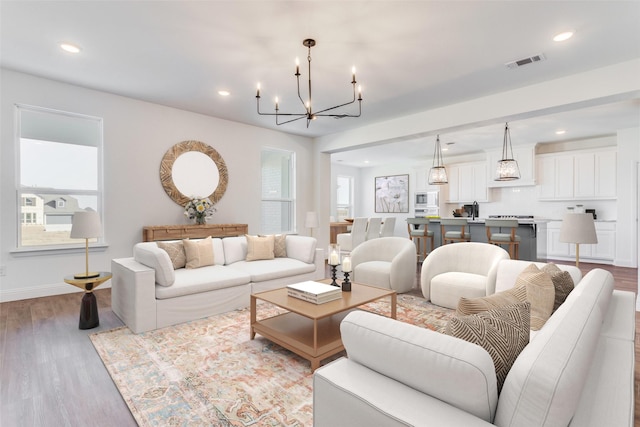 11712 Blackfoot Ct, Godley, TX 76044 - living area featuring a chandelier, recessed lighting, wood finished floors, and baseboards