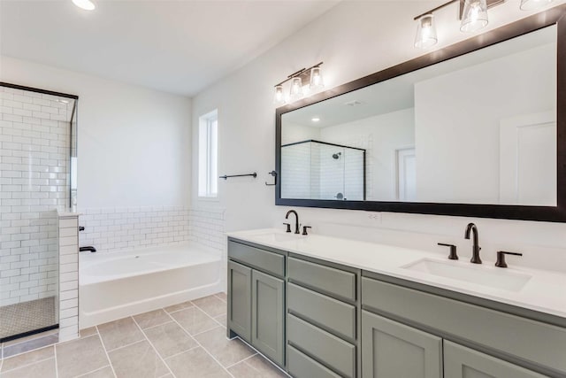 full bath with a garden tub, tile patterned floors, a sink, and a shower stall