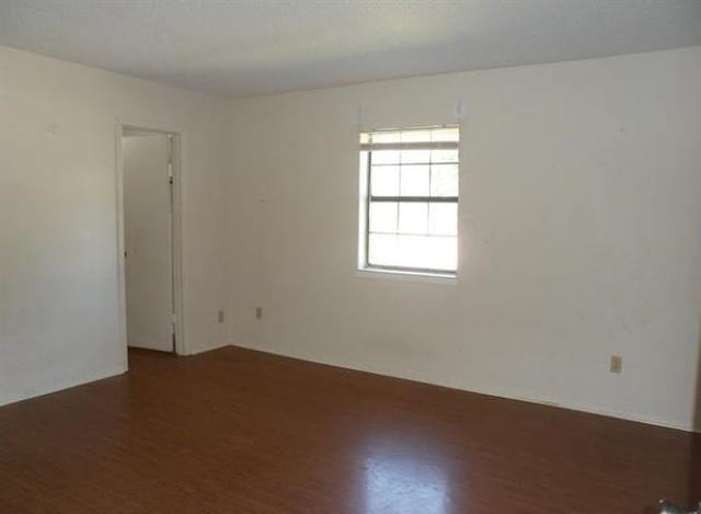 empty room with dark wood-type flooring