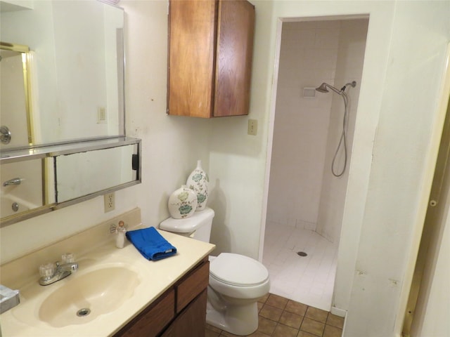 bathroom with tile patterned floors, toilet, vanity, and tiled shower