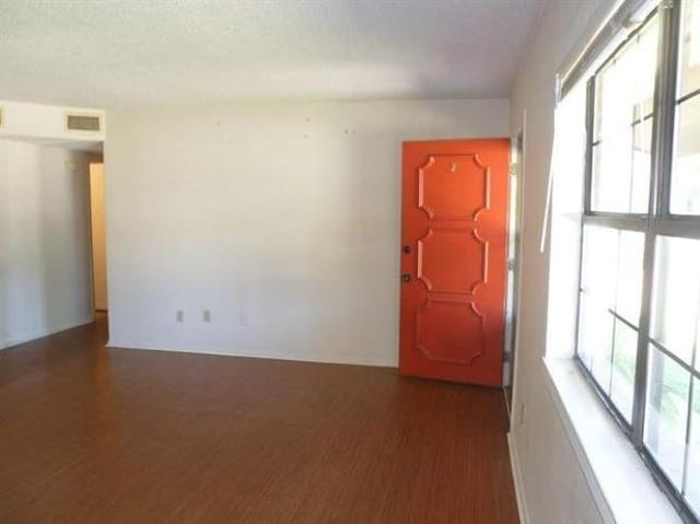 empty room featuring dark hardwood / wood-style flooring and a textured ceiling