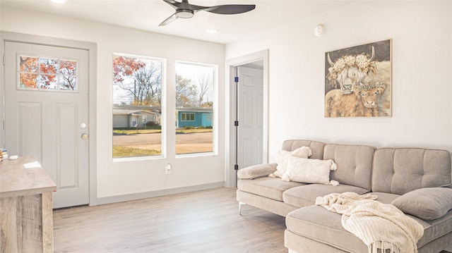 living room featuring ceiling fan and light hardwood / wood-style flooring