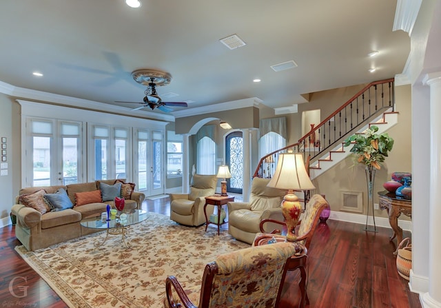 living room with dark wood-type flooring, french doors, crown molding, ceiling fan, and ornate columns