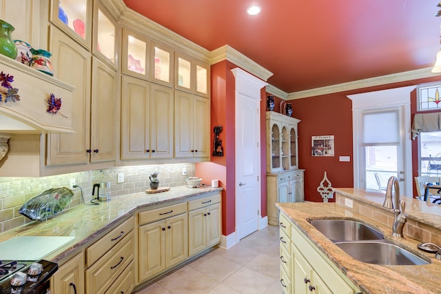 kitchen with crown molding, sink, decorative backsplash, light tile patterned floors, and light stone counters