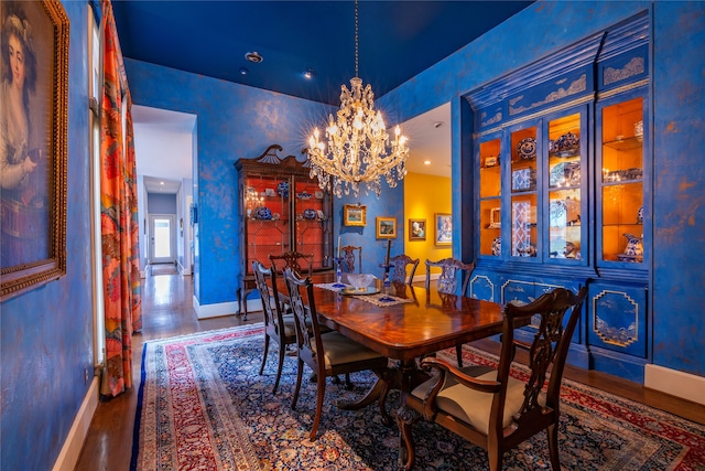 dining space featuring hardwood / wood-style flooring and a chandelier