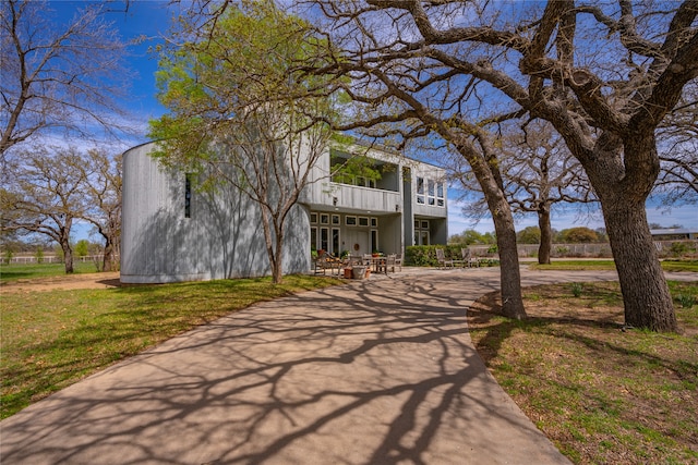 view of front of house featuring a balcony and a front lawn